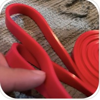 Foto de cliente mostrando el grosor de una banda de resistencia roja